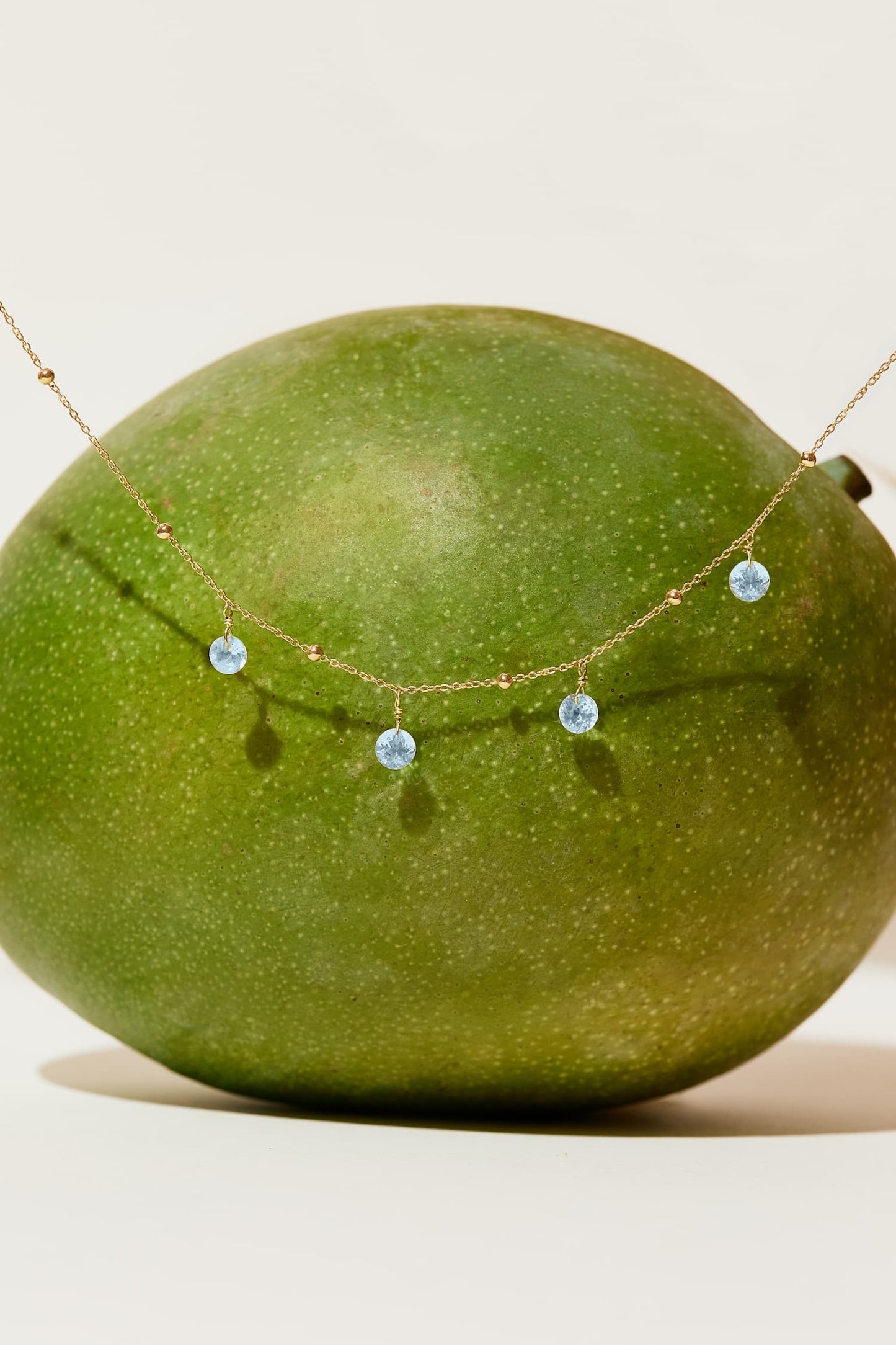 Liabelle 18K Goldkette mit hellblauen Topasen und filigranen Details