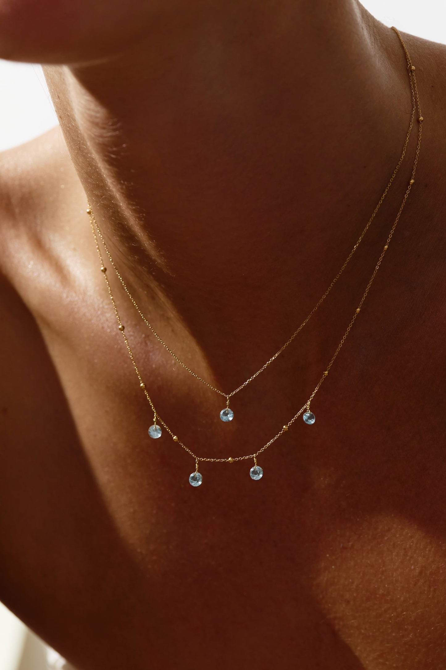 Liabelle 18K Goldkette mit hellblauen Topasen und filigranen Details